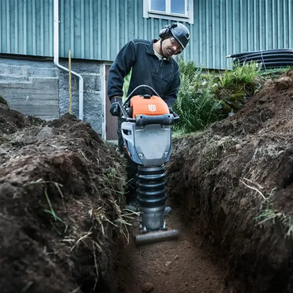 hombre usando compactador husqvarna